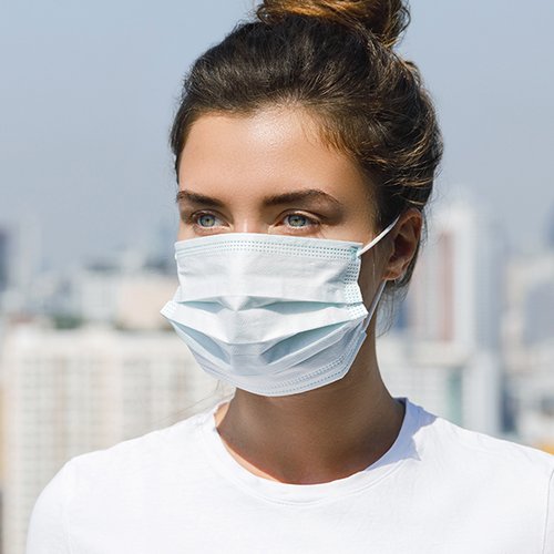 Frau mit Mund-Nasen-Schutz in der Stadt