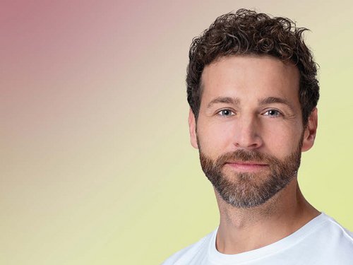 Friendly man with brown hair in front of a red-green background