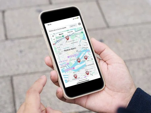 Mano che tiene uno smartphone e mostra una mappa della città.