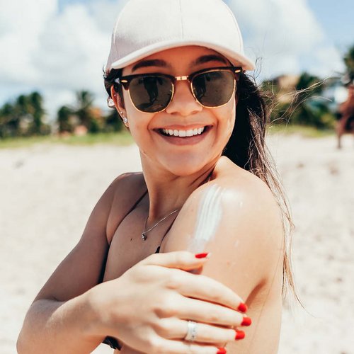 Eine junge Frau lachend am Strand