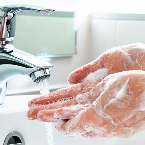 Eingeseifte Hände im Waschbecken
